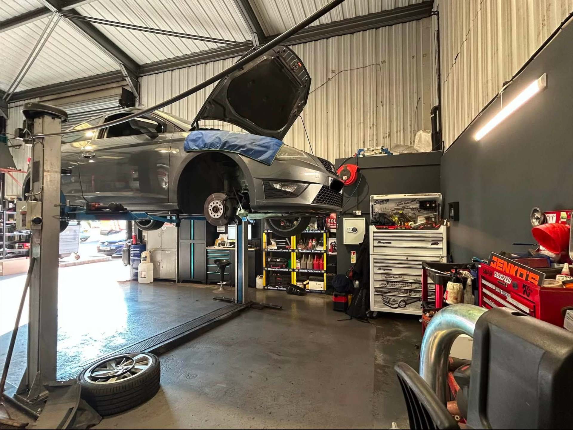 Jenko's workshop interior with a car on the ramp